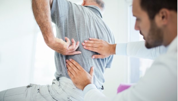 doctor treating patient indicating back pain