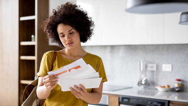 Stock photo of a young woman opening her mail